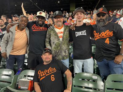 Group of friends smiling at a baseball game.