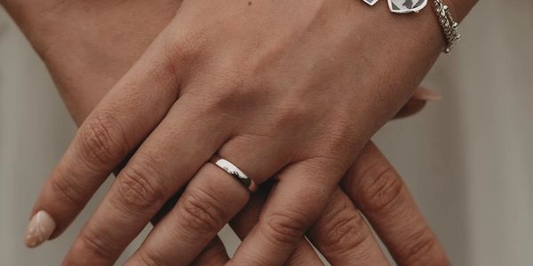 Close-up of hands with a silver ring and a bracelet.