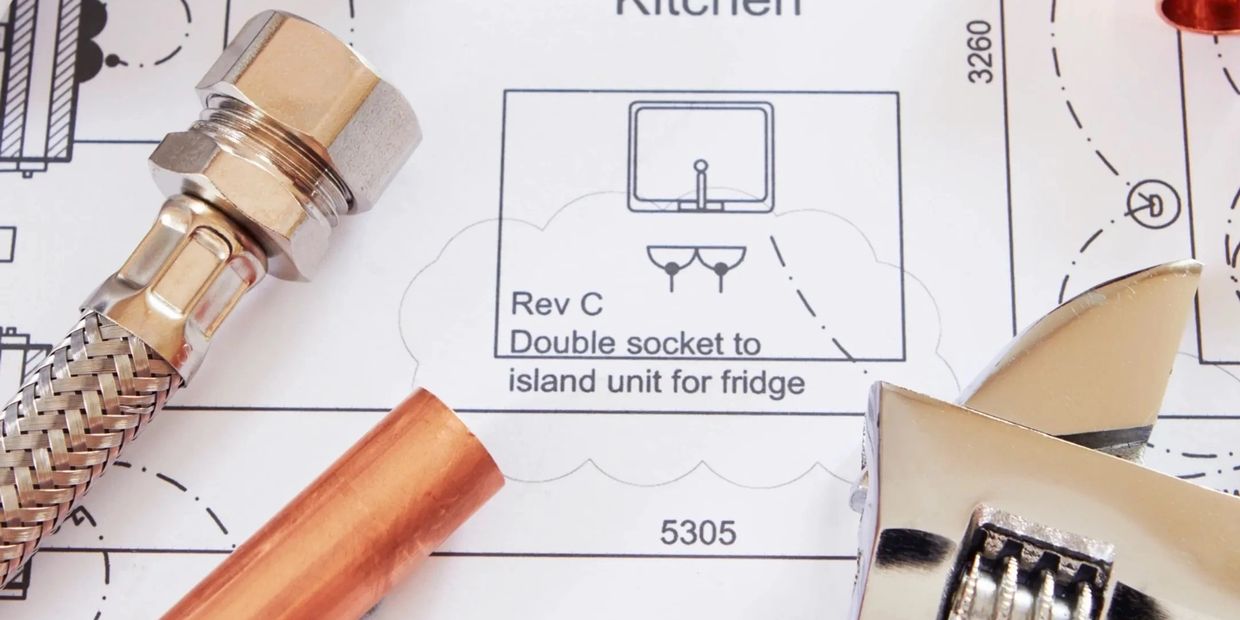 Plumbing tools on a kitchen blueprint.