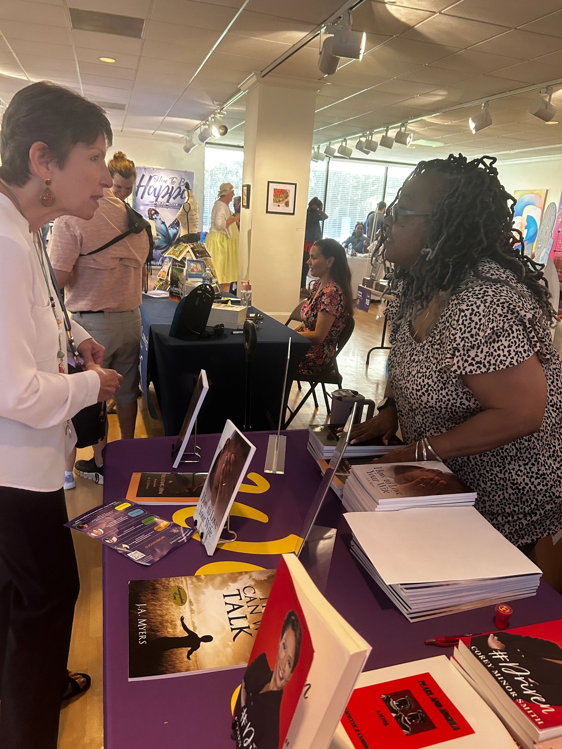 Two women talk at a book signing event.