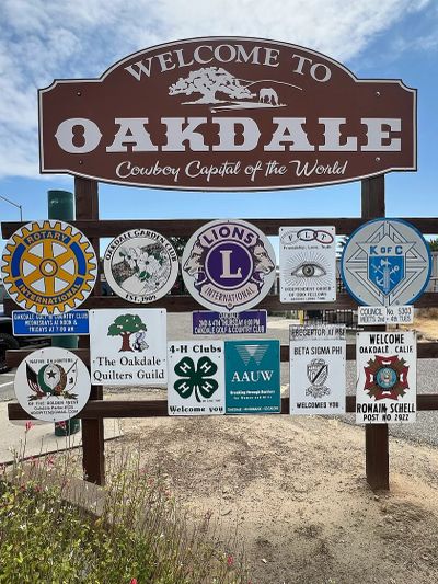 Welcome sign for Oakdale with various community clubs' logos.