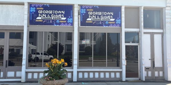 Storefront with signs announcing Georgetown Fun & Games coming soon.