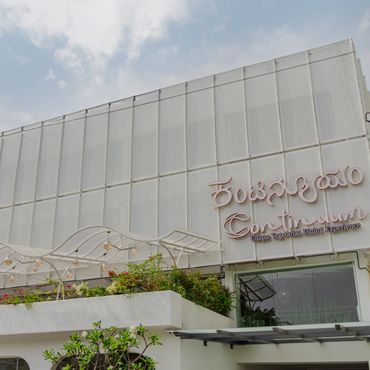 Exterior of a modern building with a sign in a regional language.