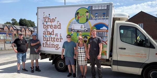 Group of five people in front of a delivery truck with colorful artwork.