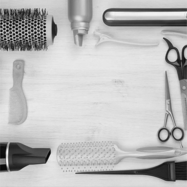 Hair styling tools and accessories arranged neatly on a wooden surface.