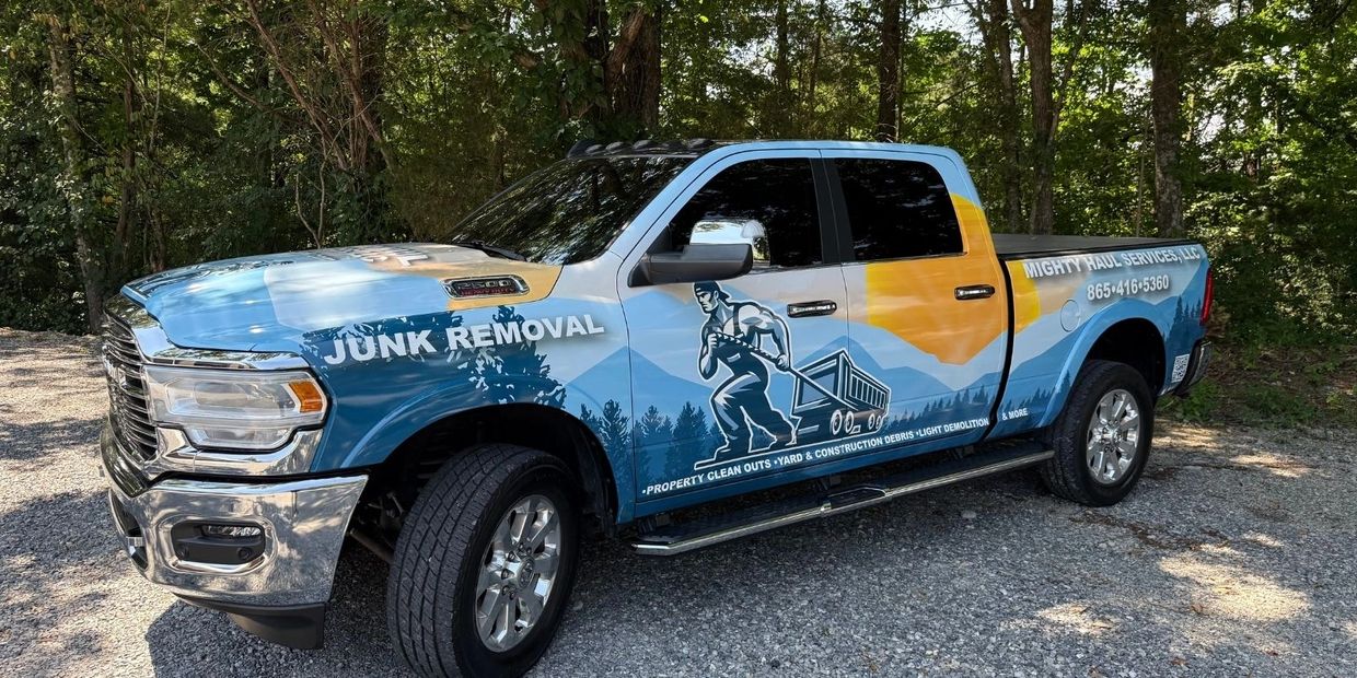 Mighty Haul junk removal truck parked on gravel in Knoxville, TN forested area