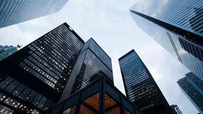 Skyscrapers viewed from below against a cloudy sky.