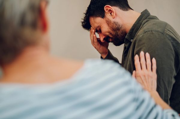 Counselor supporting distressed man emotionally