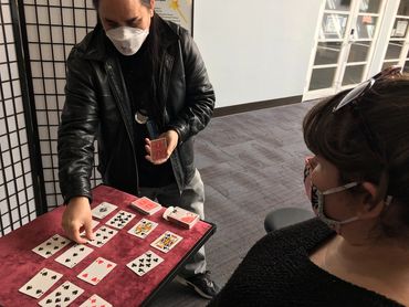 Chris teaches the fine points of a self-working card trick for Courtney.