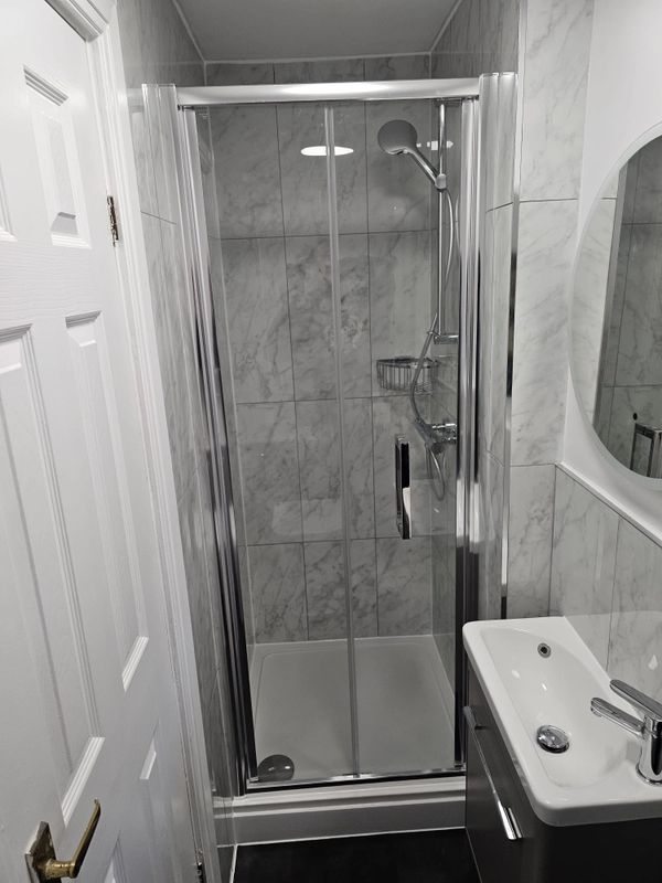 Modern bathroom with glass shower and marble tiles.