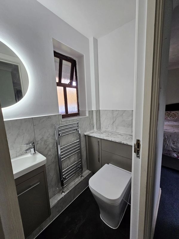 Compact modern bathroom with sleek fixtures and marble accents.
