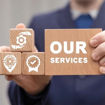 Person holding wooden blocks with 'Our Services' and icons representing services.