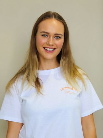 Smiling young woman with long hair wearing a white T-shirt.