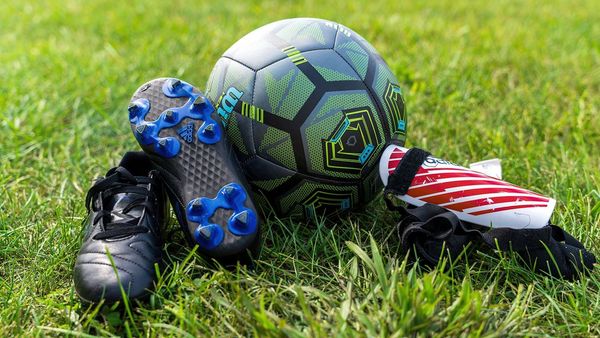 cleats, ball, and shin guards on the grass