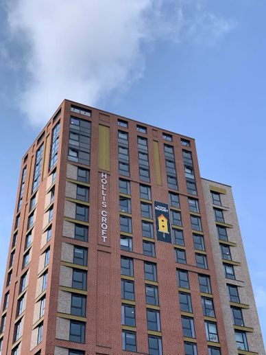 Tall modern building with "Holis Croft" sign.