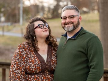 Smiling couple outdoors in a park setting.