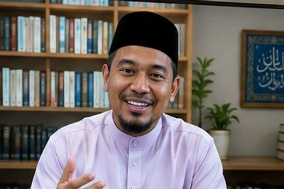 Smiling man in traditional attire speaking.