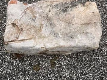 Weathered stone block on gravel.