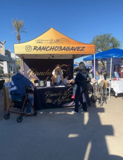 Outdoor booth for Rancho 3 Agavez with visitors.