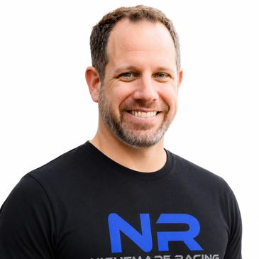 Smiling man wearing a black NR shirt.