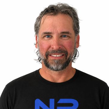 Smiling man with beard and black shirt.