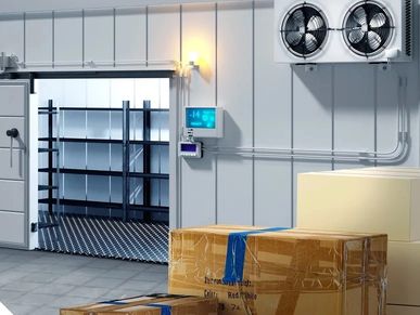 Cold storage room with boxes and cooling fans.