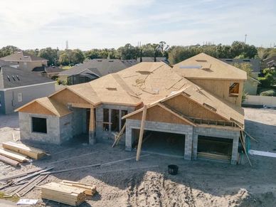 New house under construction with wooden framing and concrete blocks.