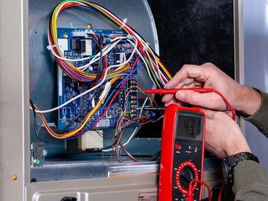 Technician measuring voltage on a circuit board using a digital multimeter.