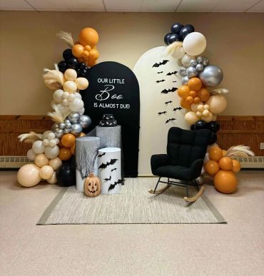 Halloween-themed baby shower setup with balloons and bat decor.