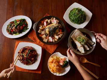 A variety of Asian dishes served on a wooden table.