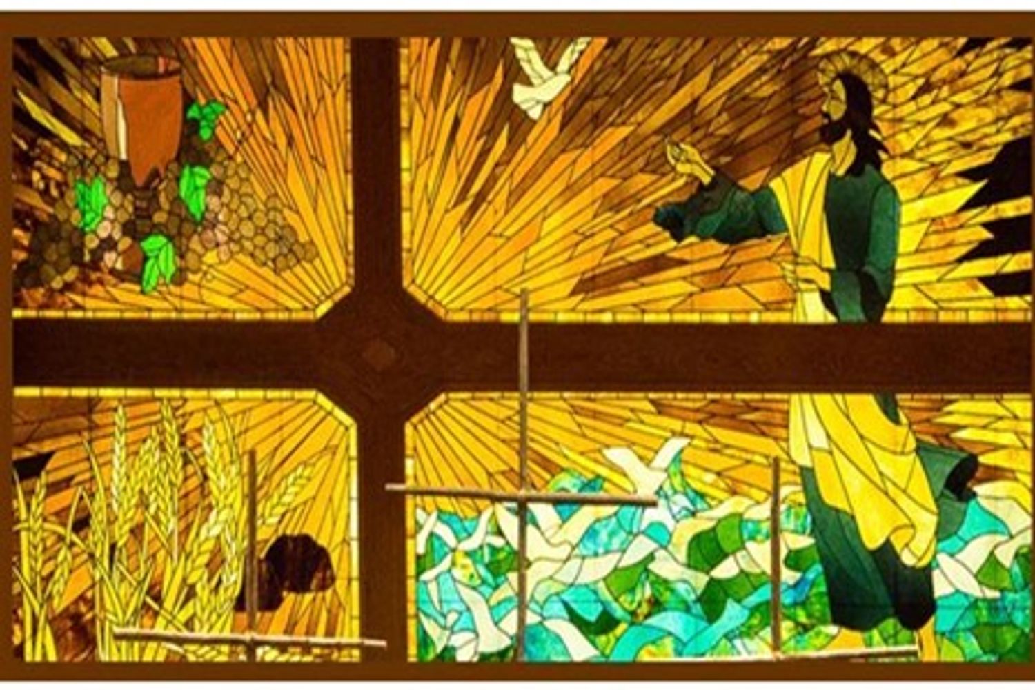 Stained glass of Jesus, dove, wheat, grapes and wine cup