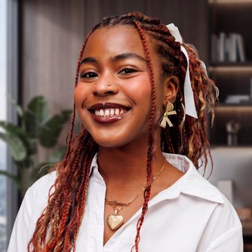 Smiling woman with braided hair and statement earrings.