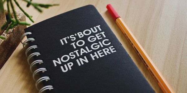 A pencil and spiral notebook that says on the cover "it's bout to get nostalgic up in here"