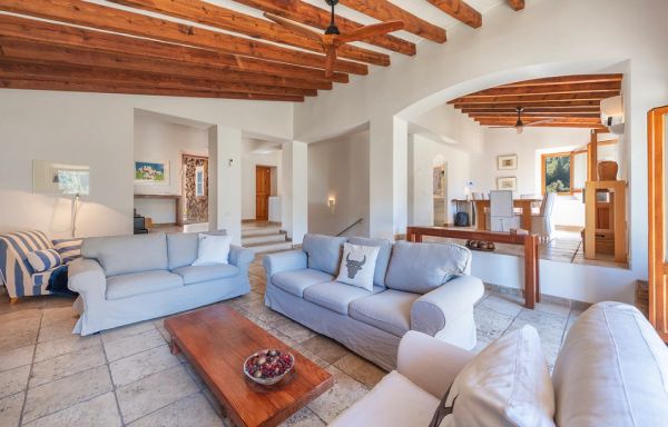 Spacious living room with wooden beams and comfortable sofas.
