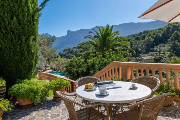 Sunny patio with mountain view and a round table.