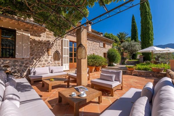 Sunny outdoor patio with comfortable seating and greenery.