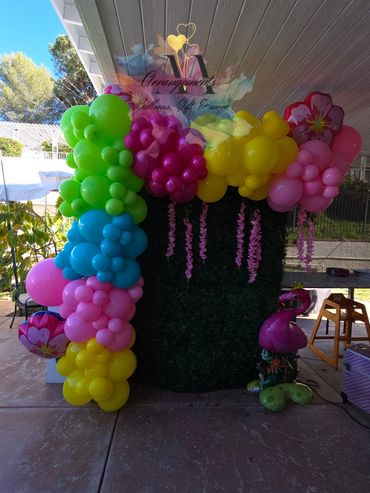 Colorful balloon arch decorating an outdoor party space.