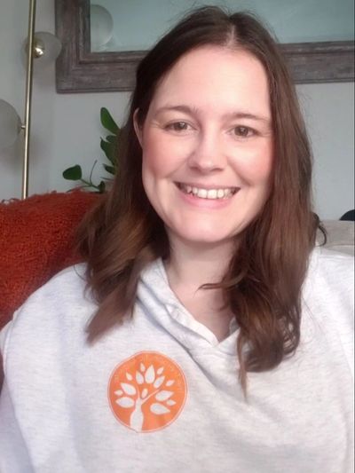 The Therapeutic Midwife Smiling in a logo jumper