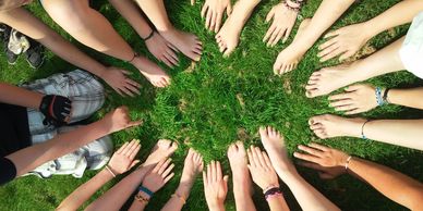 Hands touching the grass in a circle