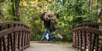 Girl jumping on bridge in celebration