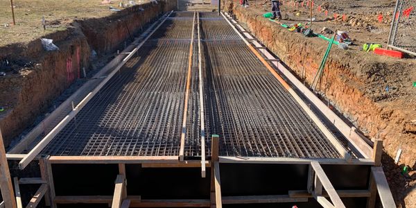 Construction site with steel reinforcement for concrete foundation.