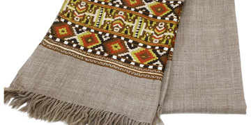Beige scarf with intricate multicolored geometric pattern and fringed edges.
