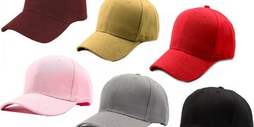 A collection of six solid-colored baseball caps in various colors.