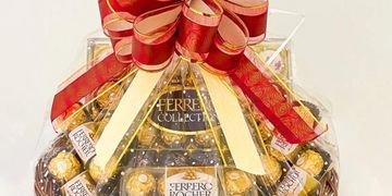 Elegant Ferrero Rocher gift basket with red and gold bow.