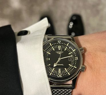 Elegant Longines automatic wristwatch with black dial and mesh strap.