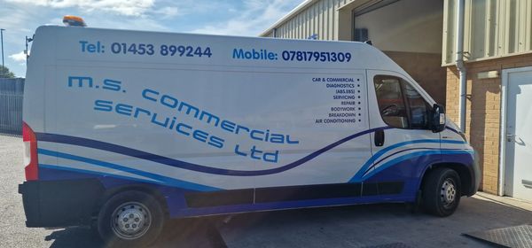 White commercial van with blue lettering and stripes.