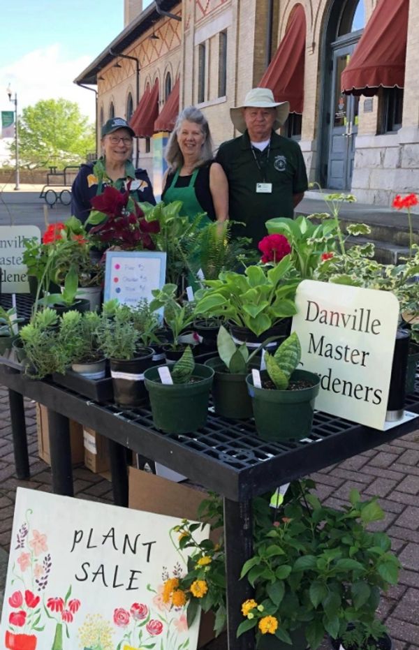 Three people at a plant sale by Danville Master Gardeners.