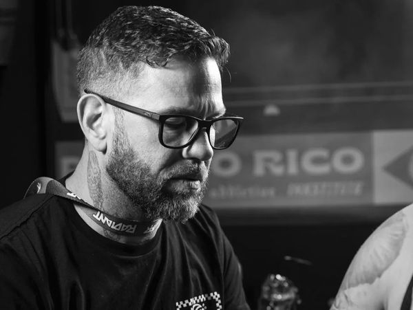 Black and white portrait of a man with glasses and a beard.
