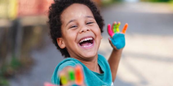 Young child using finger paints in early childhood education at Nedlof’s Teach1Reach1Premier Academy