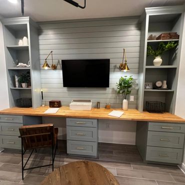 Modern home office with shiplap wall and built-in shelves.
